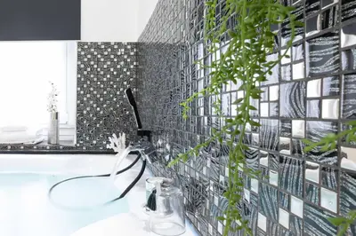 a bathroom with a black and white tile wall at Trastevere Silver King Jacuzzi Suite in Rome