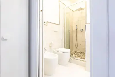 a white bathroom with a toilet and a shower at Trastevere Silver King Jacuzzi Suite in Rome