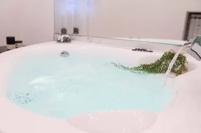 a bath tub filled with blue water in a bathroom at Romantic Jacuzzi Suite Trastevere in Rome