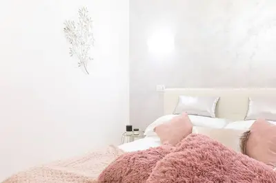 a white bedroom with a pink blanket on a bed at Romantic Jacuzzi Suite Trastevere in Rome