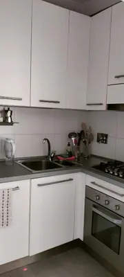 a kitchen with white cabinets and a sink and a stove at Appartamento Musei Vaticani in Rome