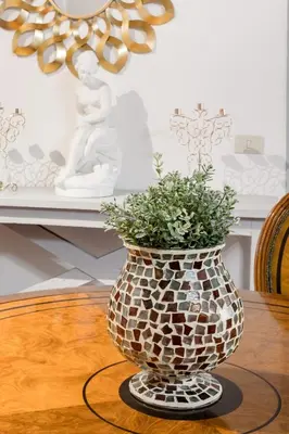 a vase sitting on a table with a plant in it at Decor Inspiration Apartment in Rome