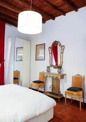 a bedroom with a bed and chairs and a mirror at Decor Inspiration Apartment in Rome