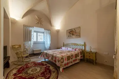 a bedroom with a bed and a chair and a window at GuestHost - Palazzo Altieri Elegant Apartment in Rome