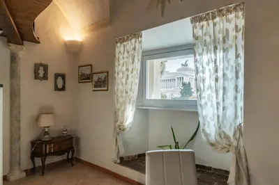 a room with a window and a table and a chair at GuestHost - Palazzo Altieri Elegant Apartment in Rome