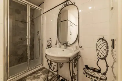 a bathroom with a sink and a shower and a mirror at GuestHost - Palazzo Altieri Elegant Apartment in Rome