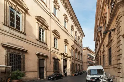 a white van parked on a street next to buildings at GuestHost - Palazzo Altieri Elegant Apartment in Rome