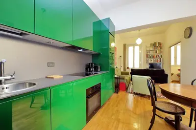 a kitchen with green cabinets and a dining room at Laterano in Rome
