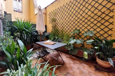 a patio with a table with plants and an umbrella at Laterano in Rome