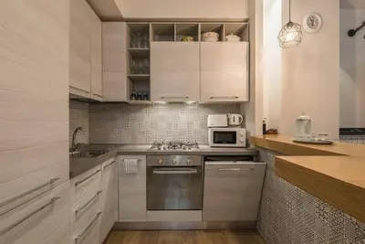 a kitchen with white cabinets and a stove top oven at La luna nel pozzo a Roma in Rome