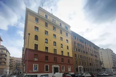 a yellow building with cars parked in front of it at La luna nel pozzo a Roma in Rome