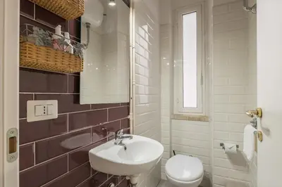 a white bathroom with a sink and a toilet at Charming Mazzini Apartment in Rome