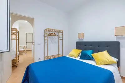 a bedroom with a blue bed with yellow and blue pillows at Elle Cavour Apartment in Rome