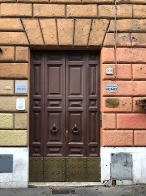 a large brown door in a brick wall at Elle Cavour Apartment in Rome