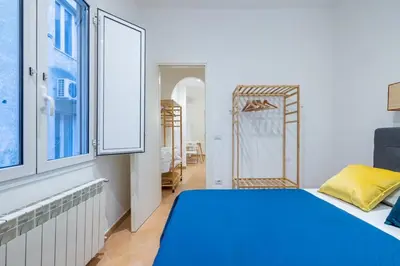 a bedroom with a blue bed and a window at Elle Cavour Apartment in Rome