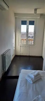 a white room with a bed and a large window at Terrace on the 11th floor in Rome