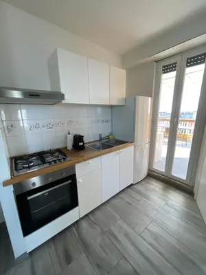 a kitchen with white cabinets and a stove top oven at Terrace on the 11th floor in Rome