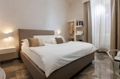 a bedroom with a large bed with white sheets at DolceVitaSuite in Rome