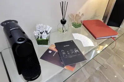a glass table with a phone and books on it at DolceVitaSuite in Rome
