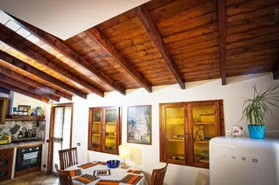 a kitchen with wooden ceilings and a table and a refrigerator at Laura's Brother - Close to St. John's Basilica in Rome