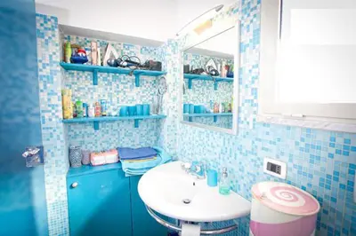 a blue tiled bathroom with a sink and a mirror at Laura's Brother - Close to St. John's Basilica in Rome