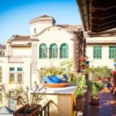a building with green windows and potted plants on a balcony at Laura's Brother - Close to St. John's Basilica in Rome