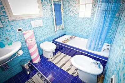 a blue tiled bathroom with a toilet and a sink at Laura's Brother - Close to St. John's Basilica in Rome