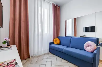 a living room with a blue couch with pillows on it at Pantheon Boutique Apartment 