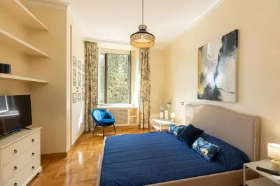 a bedroom with a blue bed and a tv at Ludovisi by Rental in Rome in Rome