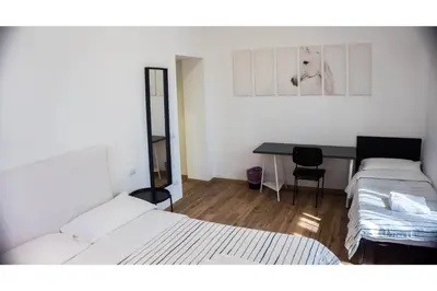 a room with two beds and a desk with a dog on the wall at Cosmo GuestHouse in Rome