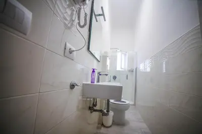 a white bathroom with a toilet and a mirror at Cosmo GuestHouse in Rome