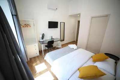 a bedroom with a bed with yellow pillows and a desk at Cosmo GuestHouse in Rome
