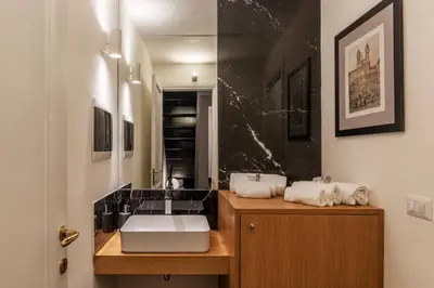 a bathroom with a sink and a black marble wall at Toscana 1 - FromHometoRome in Rome