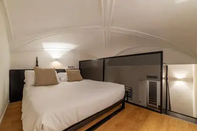 a bedroom with a large bed with a white ceiling at Toscana 1 - FromHometoRome in Rome