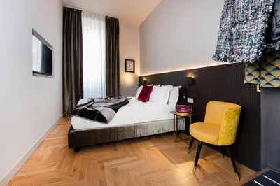 a hotel room with a bed and a yellow chair at Piazza di Spagna 66 Luxury Apartment - Maison D'Art Collection in Rome