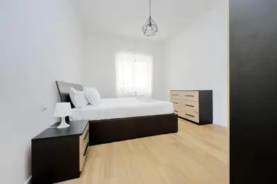 a bedroom with a bed and a dresser in it at suity I cozy segesta apartment in Rome