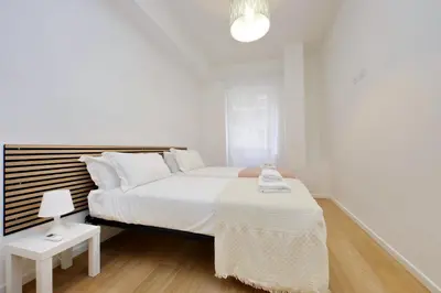 a white bedroom with a large bed and a table at suity I cozy segesta apartment in Rome