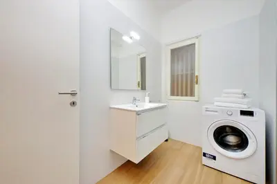 a bathroom with a washing machine and a sink at suity I cozy segesta apartment in Rome