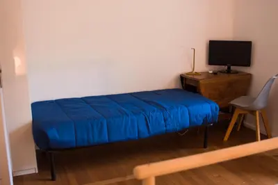 a blue bed in a room with a desk and a chair at Traversari 27 in Rome