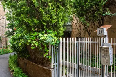a white fence with a sign in front of a building at Traversari 27 in Rome