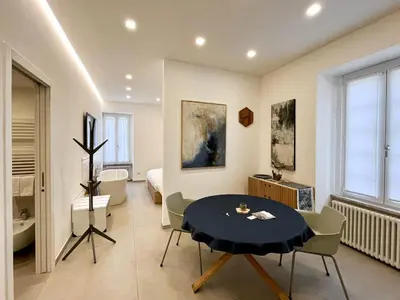 a living room with a table and a bedroom at TRASTEVERE URBAN SUITE in Rome