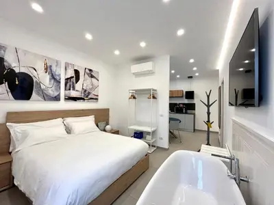 a bedroom with a white bed and a bath tub at TRASTEVERE URBAN SUITE in Rome