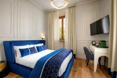 a blue and white bedroom with a bed and a desk at Navona Sky Palace in Rome