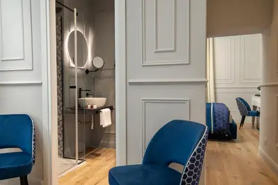 a living room with blue chairs and a mirror at Navona Sky Palace in Rome