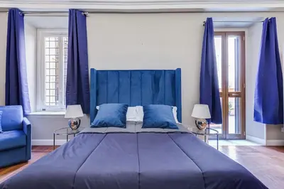 a blue bedroom with a large bed and blue curtains at SPANISH GARDEN in Rome