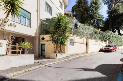 a house with a red car parked on the side of a street at Classy Apartment - Auditorium & Villa Borghese in Rome