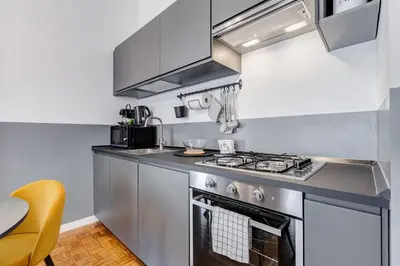 a kitchen with a stove top oven next to a table at Classy Apartment - Auditorium & Villa Borghese in Rome