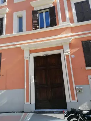 a building with a wooden door and a motorcycle parked in front at SCIPIO92HOME in Rome