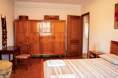 a bedroom with a bed and a wooden cabinet at Casa Marta in Rome