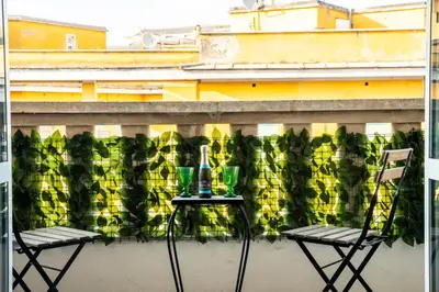 two chairs and a table on a balcony at Casa Marta in Rome